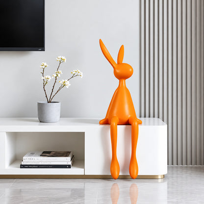 Rabbit resin sculpture on a media console adding a playful modern touch