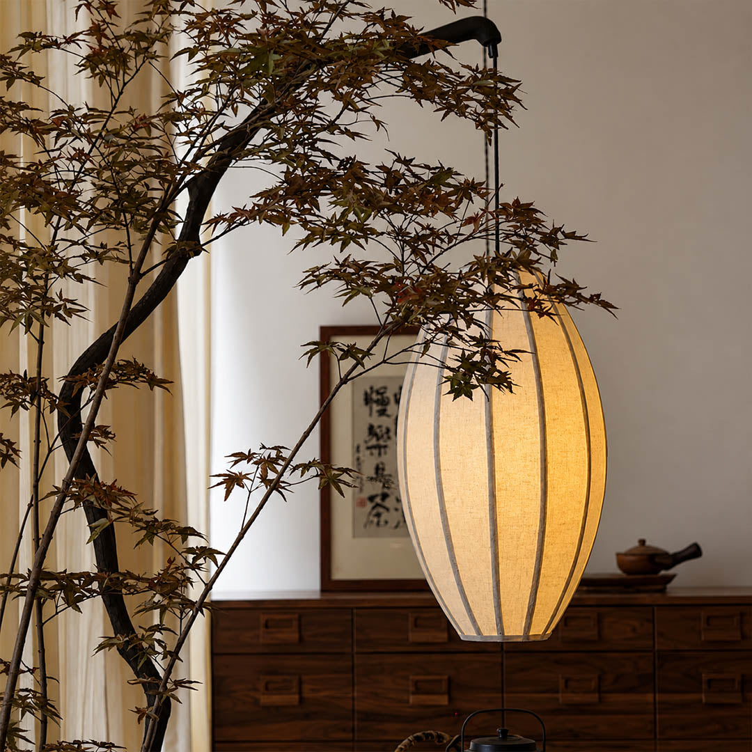 Ramo floor lamp illuminated warm ambient glow through oval fabric shade evening cozy intimate sculptural tree sophisticated Japandi wabi-sabi detail close up mood
