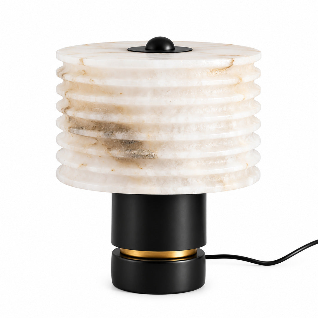 Sasso table lamp with a glowing natural alabaster shade on a black base on a nightstand