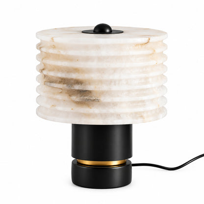 Sasso table lamp with a glowing natural alabaster shade on a black base on a nightstand