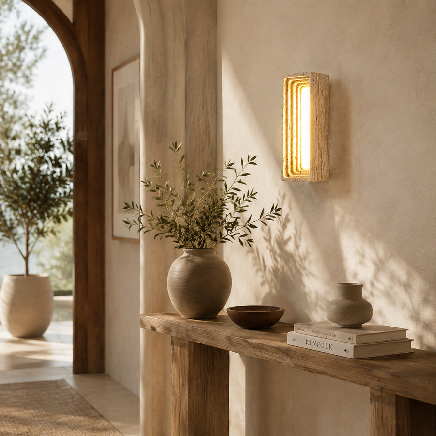 Sasso travertine wall sconce entryway foyer warm glow travertine stone column walnut American home lifestyle interior styled