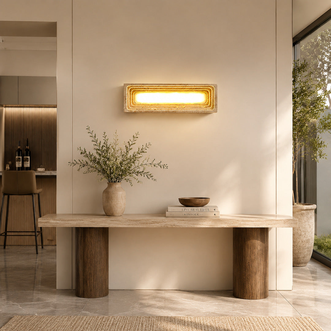 Sasso travertine wall sconce entryway foyer warm glow travertine stone column walnut American home lifestyle interior styled