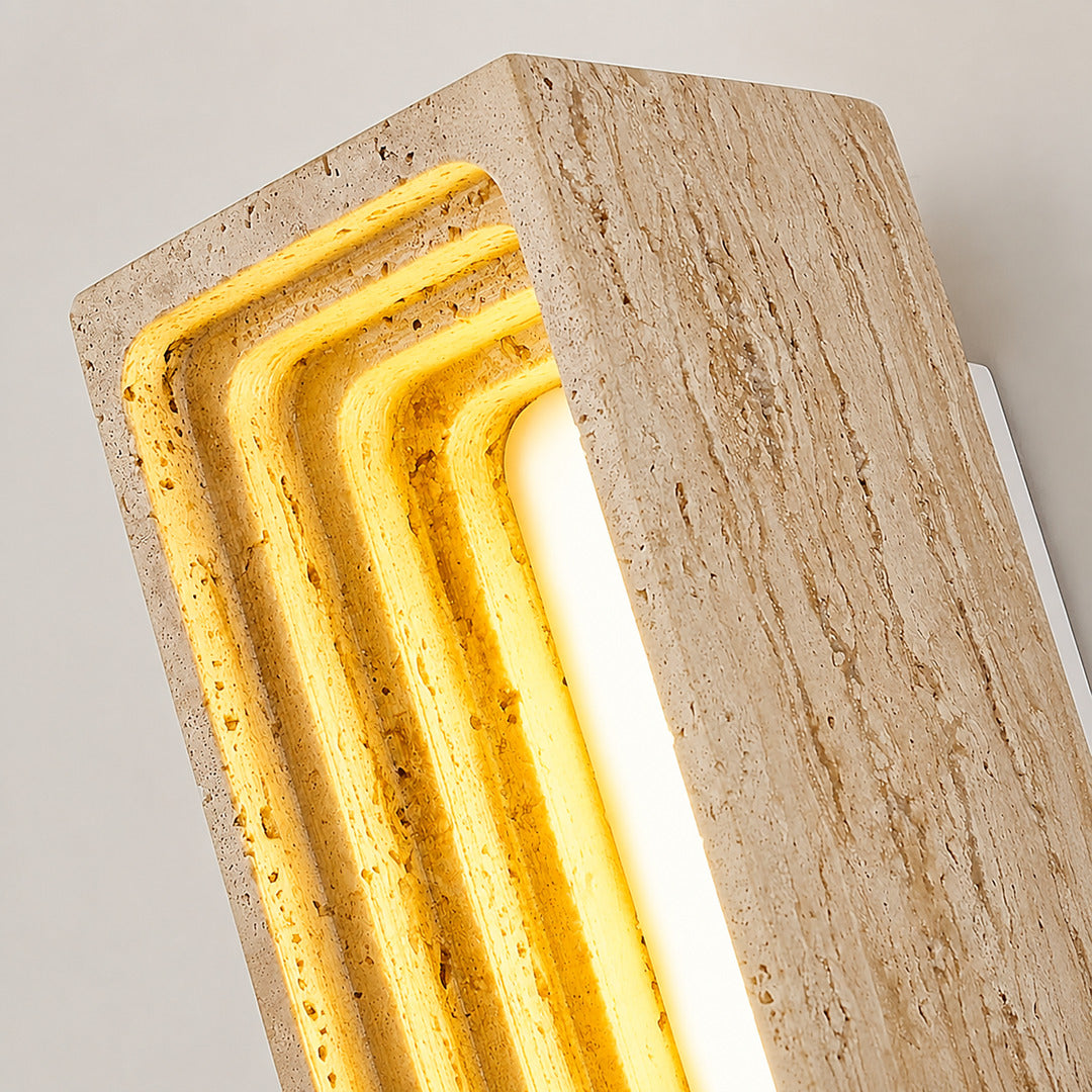 Sasso travertine wall sconce illuminated warm light glowing stone veining amber detail close up