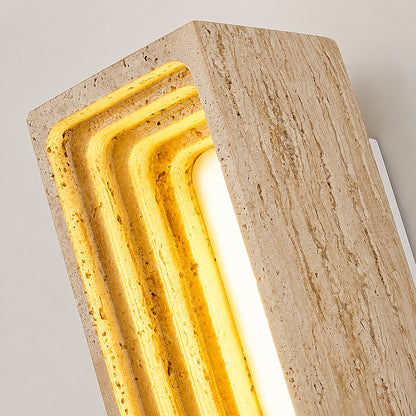 Sasso travertine wall sconce illuminated warm light glowing stone veining amber detail close up