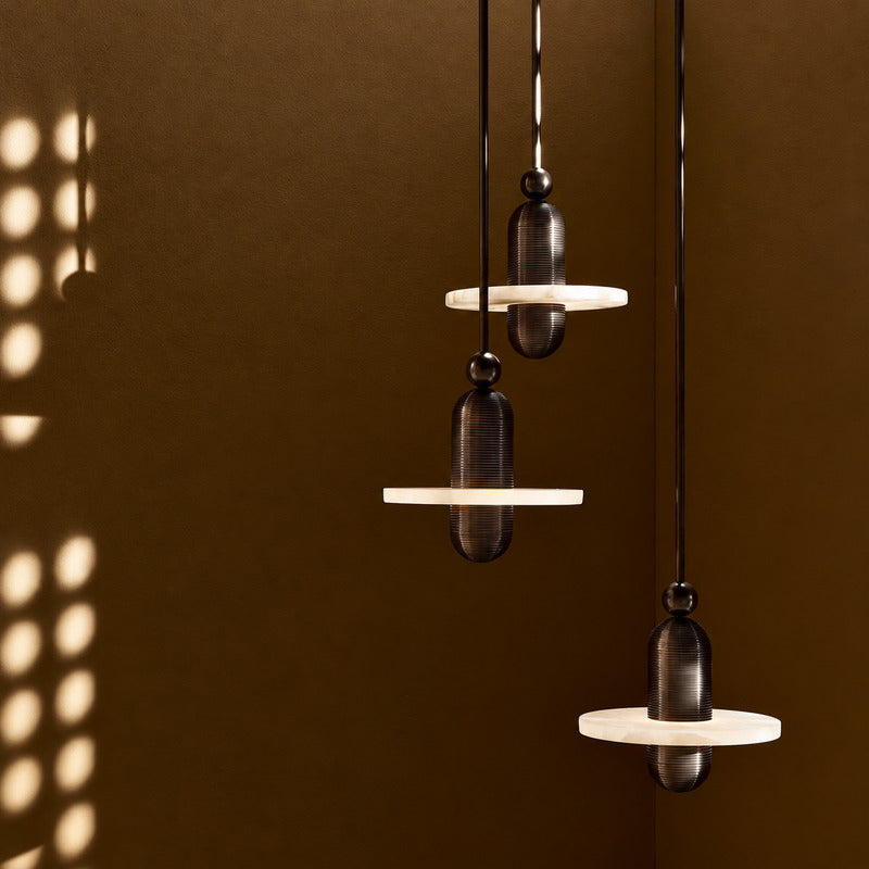Double-disc Saturno alabaster pendant cascading in an open staircase stairwell