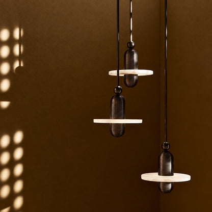 Double-disc Saturno alabaster pendant cascading in an open staircase stairwell