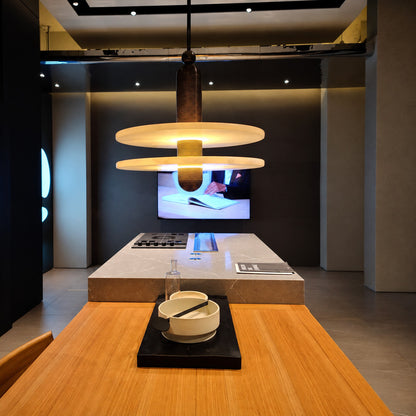 Row of single-disc Saturno alabaster pendants suspended over a modern kitchen island