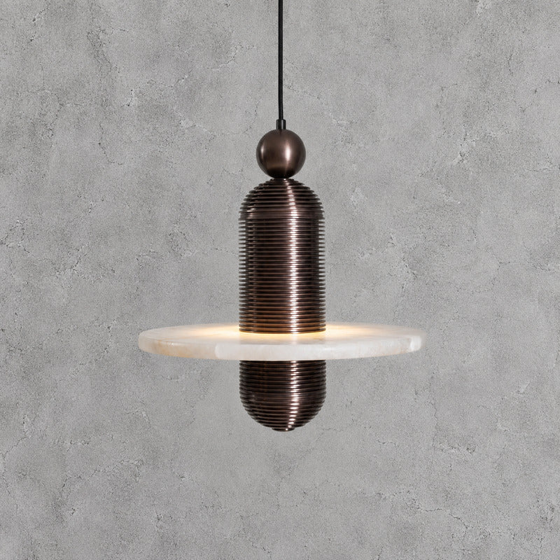 Single-disc 7.1-inch black Saturno alabaster pendant as a compact accent in a hallway