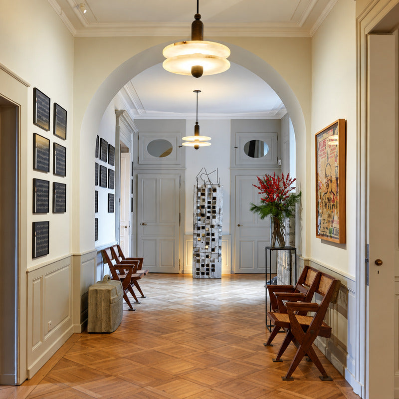 Double-disc Saturno alabaster pendant welcoming guests in a double-height entryway