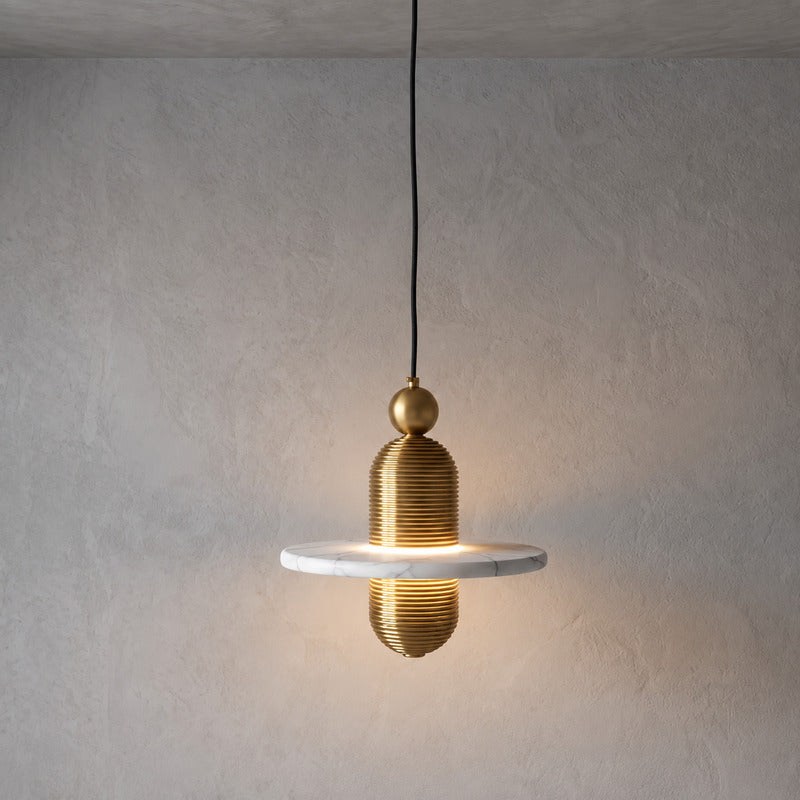 Single-disc 7.1-inch gold Saturno alabaster pendant over a kitchen island or bedside