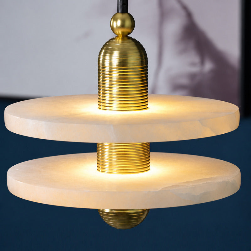 Close-up of the natural alabaster disc threaded on the ribbed metal column of the Saturno pendant like a ring in orbit