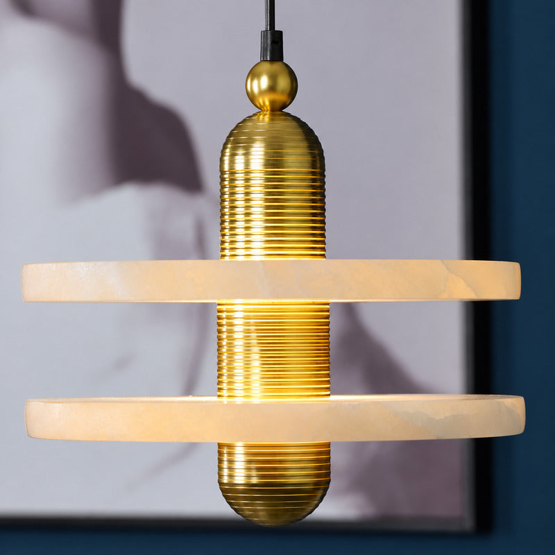 Close-up of the natural alabaster disc threaded on the ribbed metal column of the Saturno pendant like a ring in orbit