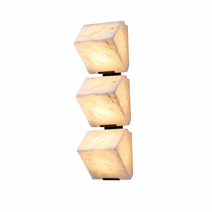Scala alabaster wall sconce with stepped natural stone panels glowing warm on a staircase wall
