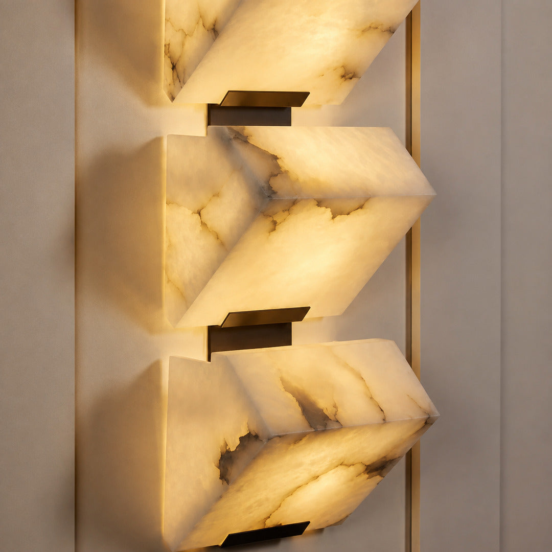Warm integrated LED glow diffusing evenly through the alabaster panels of the Scala wall sconce