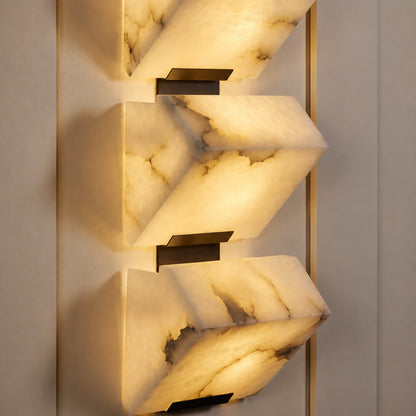 Warm integrated LED glow diffusing evenly through the alabaster panels of the Scala wall sconce