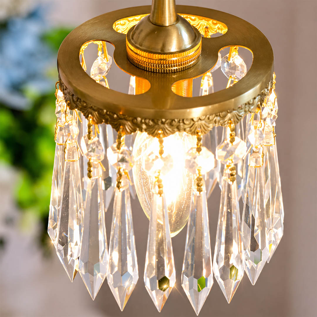 Serafino cascade pendant illuminated sparkling crystal light refraction brass angel evening magical glamorous glow detail close up mood