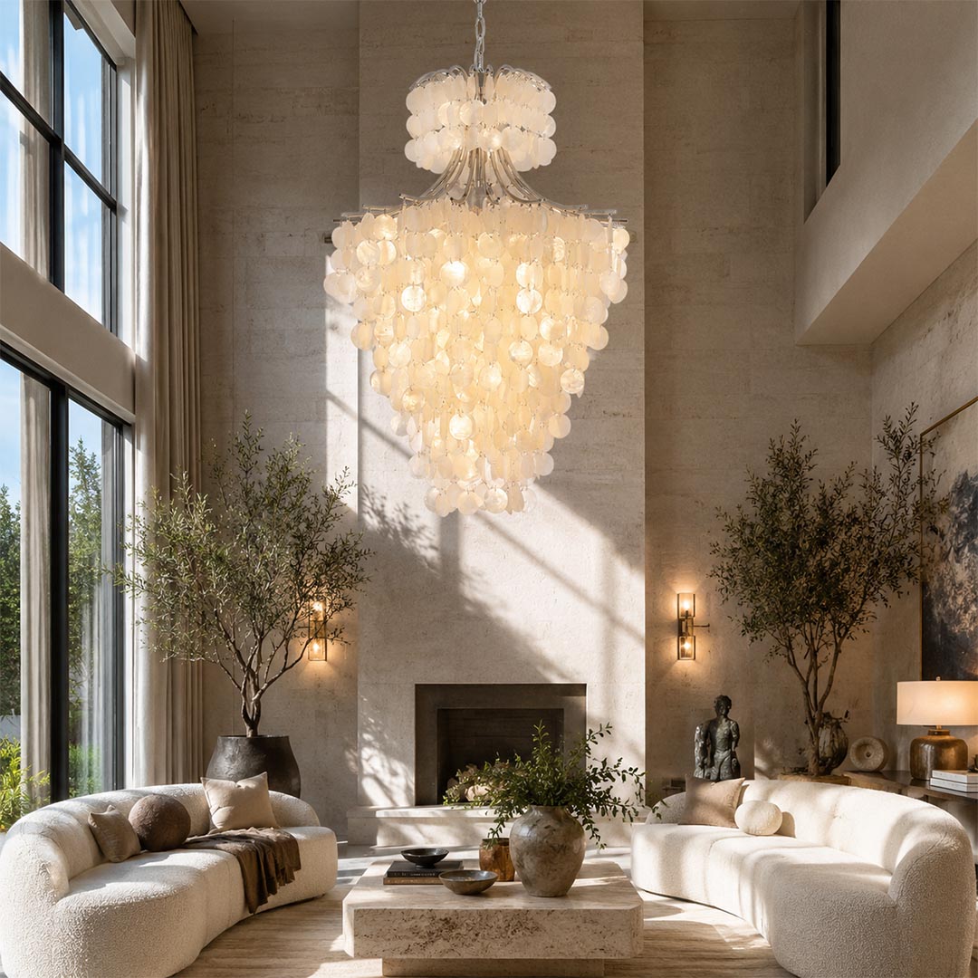 Organic modern chandelier hanging in a bright luxury living room with white sofas and a fireplace.