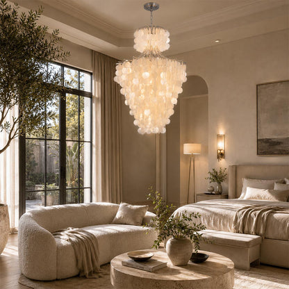 Japandi pendant light illuminating a minimalist cream bedroom with a round coffee table and plush sofa.