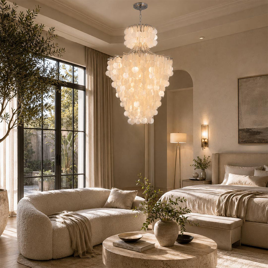 Japandi pendant light illuminating a minimalist cream bedroom with a round coffee table and plush sofa.