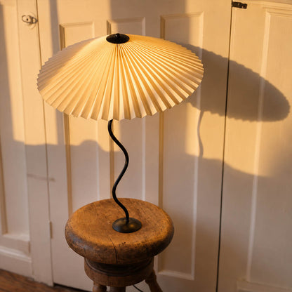 Sinuo table lamp black beige boutique hotel guest room hospitality bedside nightstand sculptural squiggle wavy metal fabric drum shade postmodern Memphis inspired warm ambient lifestyle interior