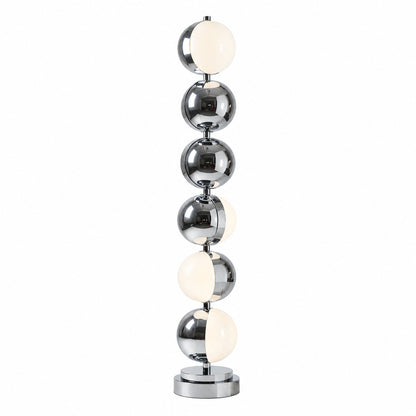 Slancio floor lamp with a slim polished chrome stem glowing warm in a modern living room corner