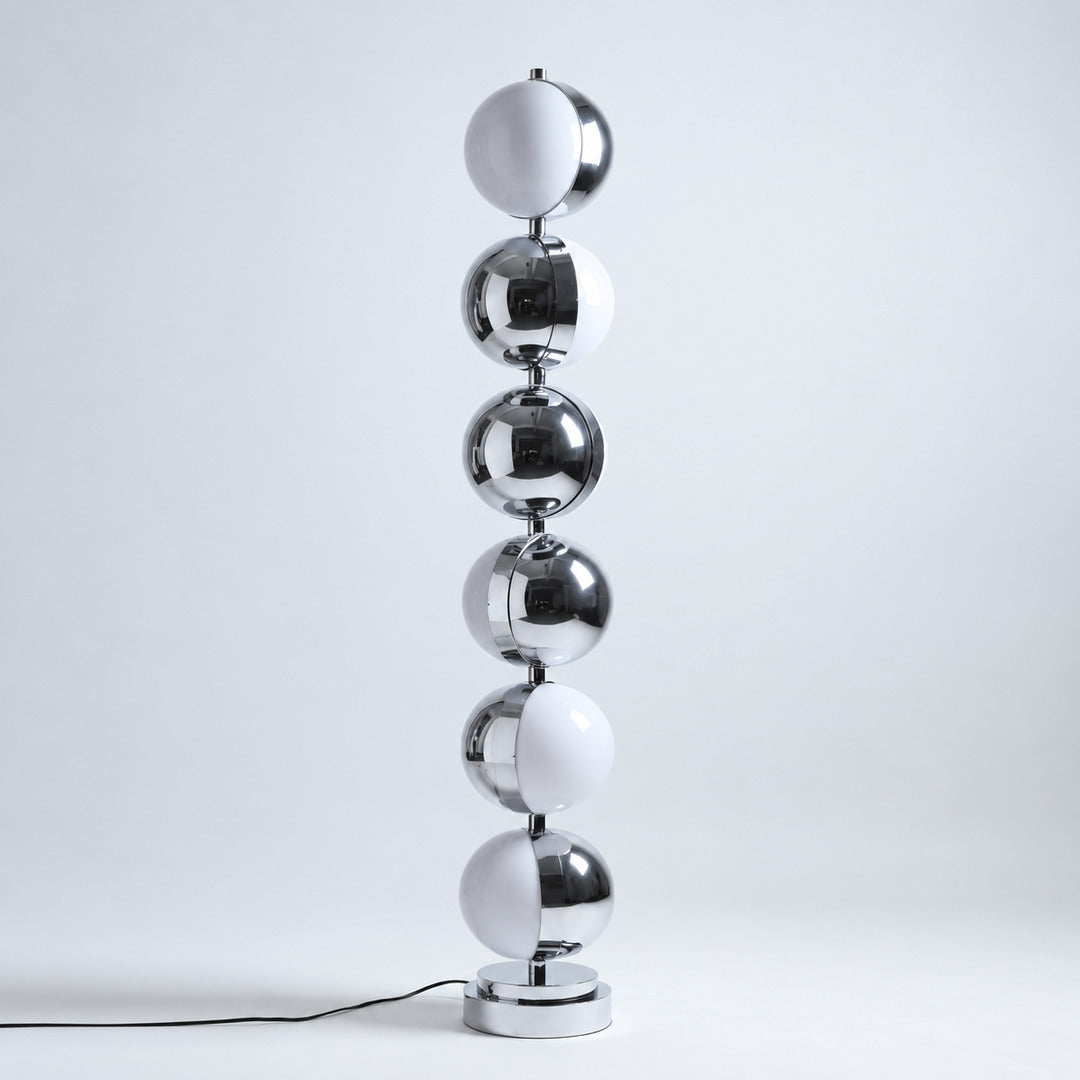 Slancio chrome floor lamp standing in a living room corner with a warm minimalist glow
