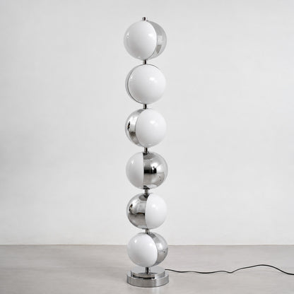 Slancio chrome floor lamp standing in a living room corner with a warm minimalist glow