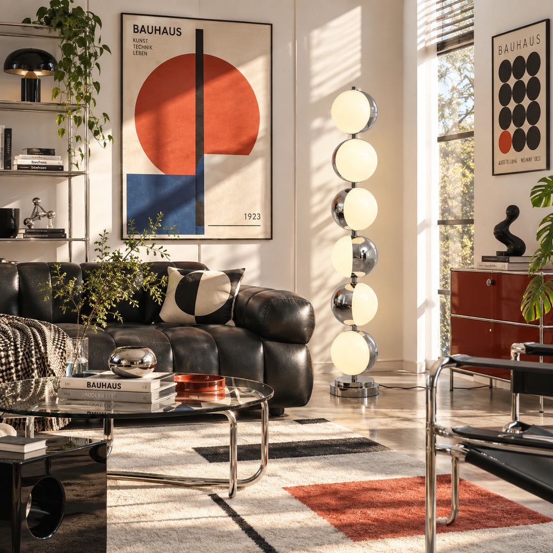 Slancio chrome floor lamp standing beside a sofa as a sleek minimalist accent