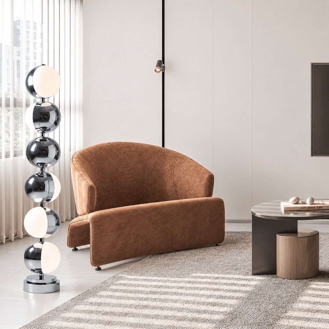 Slancio chrome floor lamp standing beside a sofa as a sleek minimalist accent