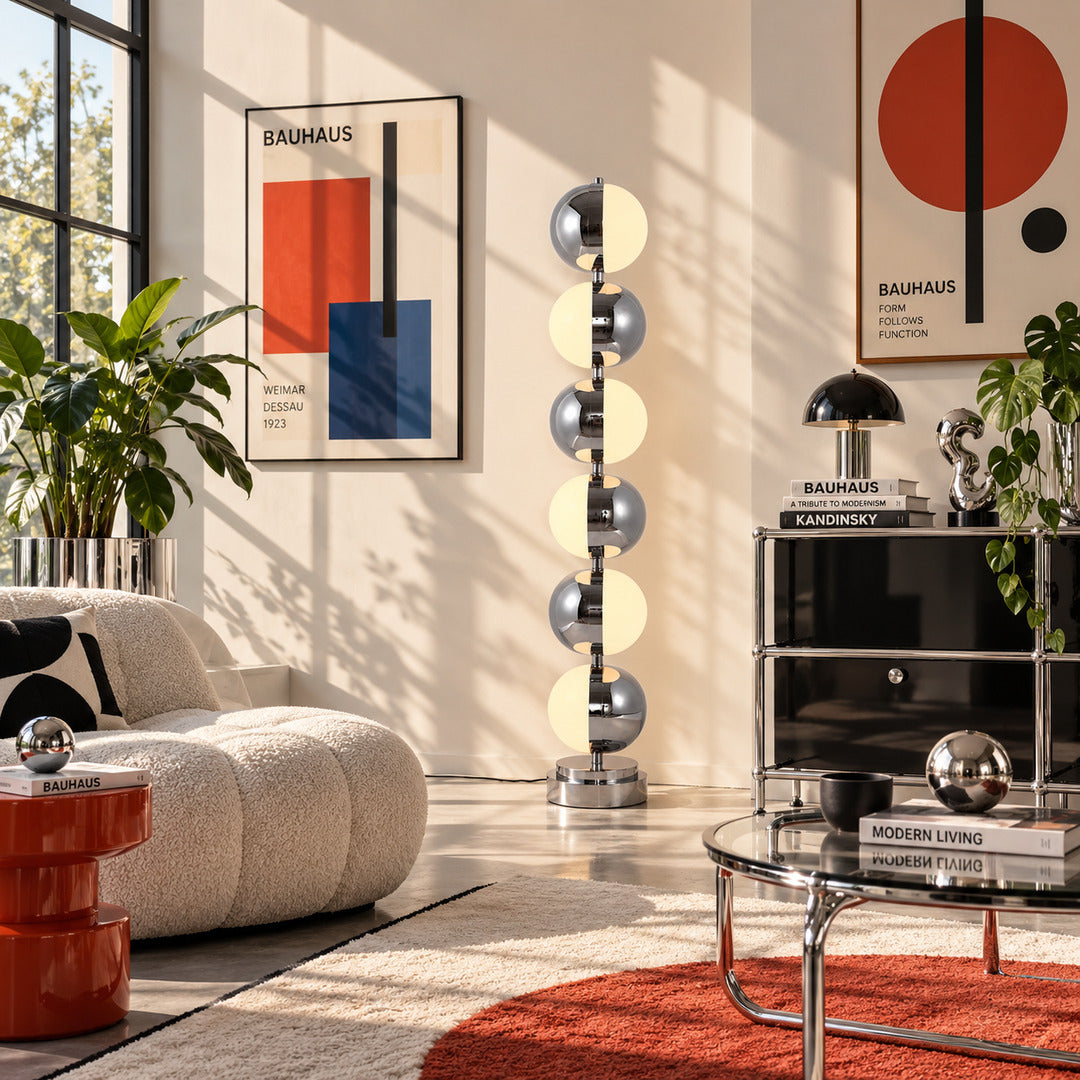 Slancio chrome floor lamp standing beside a sofa as a sleek minimalist accent