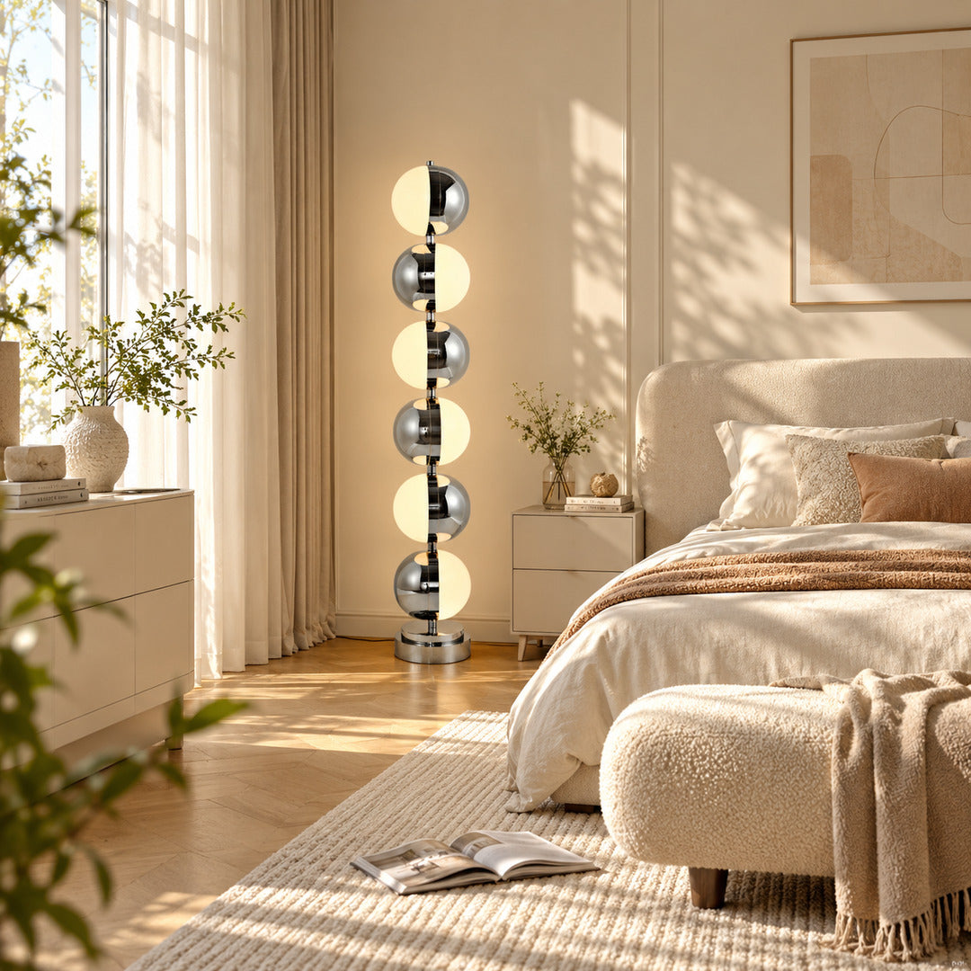 Slancio chrome floor lamp adding a soft warm glow beside a modern master bedroom bed