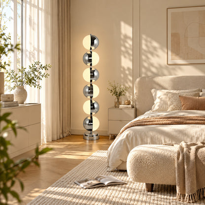 Slancio chrome floor lamp adding a soft warm glow beside a modern master bedroom bed