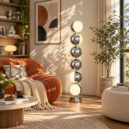 Slancio chrome floor lamp standing beside a sofa as a sleek minimalist accent