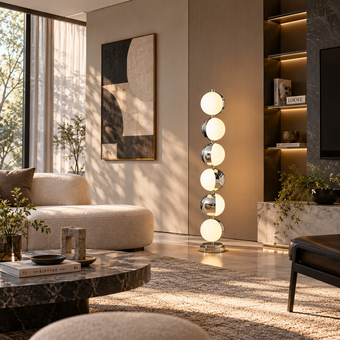 Slancio chrome floor lamp standing beside a sofa as a sleek minimalist accent