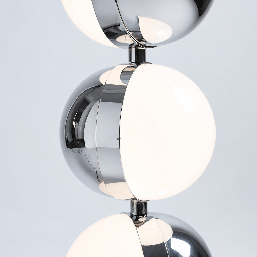 Polished chrome finish of the Slancio floor lamp reflecting the light of a modern room