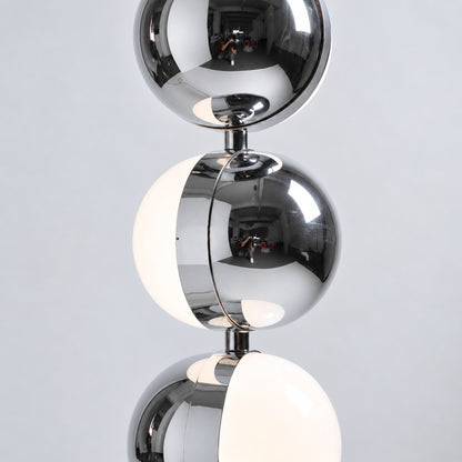 Polished chrome finish of the Slancio floor lamp reflecting the light of a modern room
