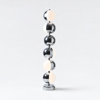 Slancio chrome floor lamp standing in a living room corner with a warm minimalist glow