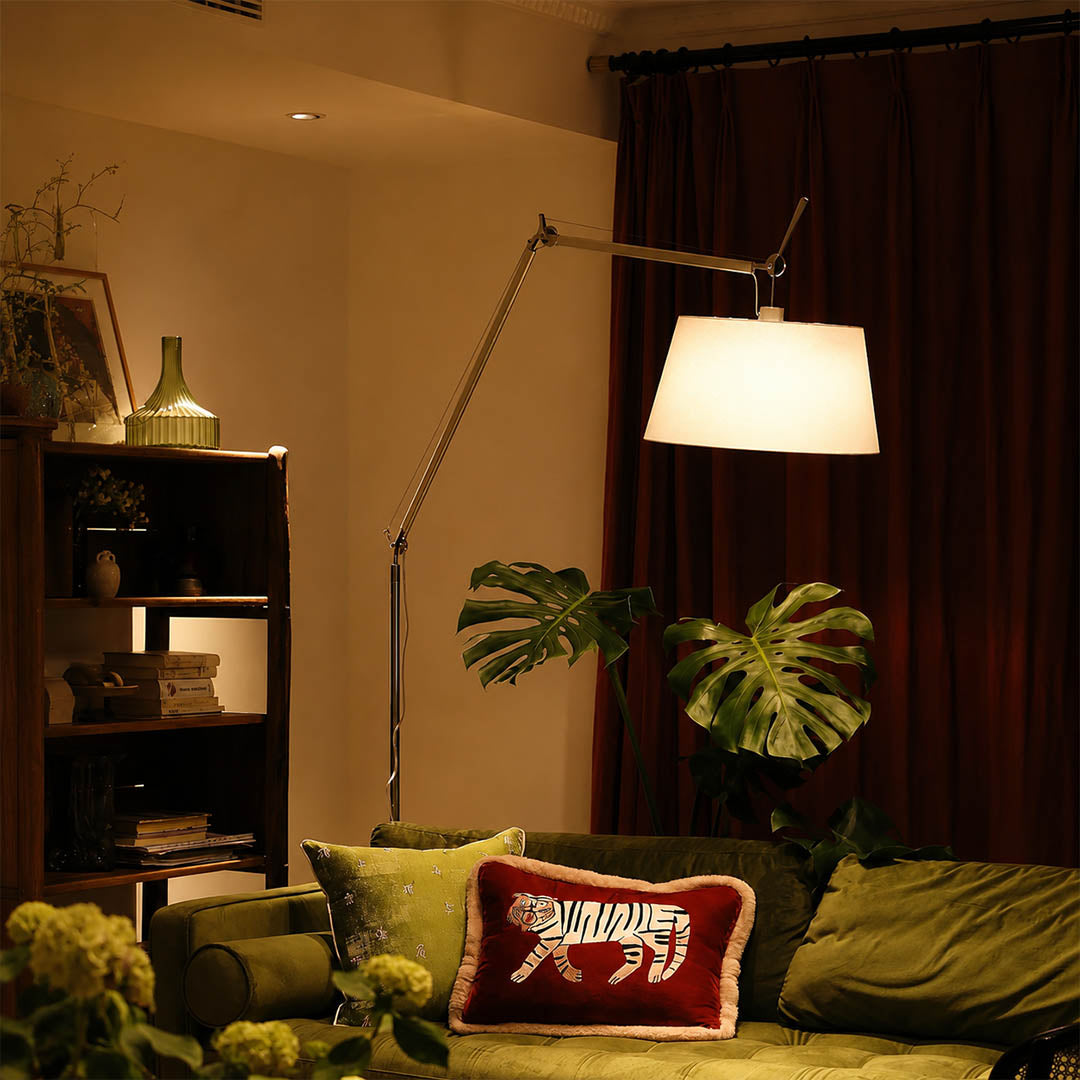 The 95.7-inch Snodo floor lamp arcing over the back of a sofa in an American living room, delivering direct reading light without a side table