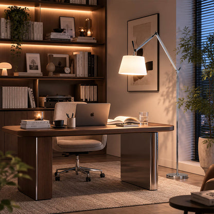 Snodo floor lamp beside a walnut desk in a home office, swing arm angled over the work surface