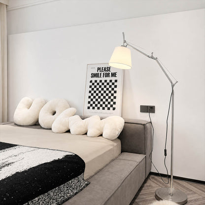 Snodo floor lamp standing beside the bed in a serene primary bedroom, used as a bedside reading light
