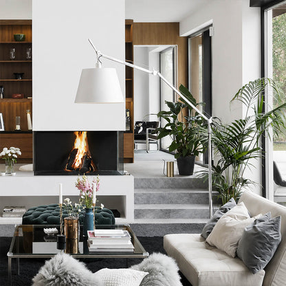 The 95.7-inch Snodo floor lamp arcing over the back of a sofa in an American living room, delivering direct reading light without a side table