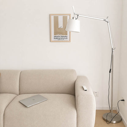 The 95.7-inch Snodo floor lamp arcing over the back of a sofa in an American living room, delivering direct reading light without a side table