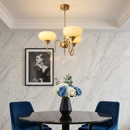 Solari cream glass chandelier above dining table warm amber gold light organic modern interior
