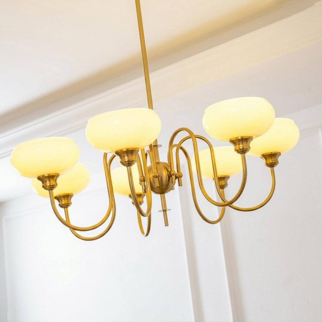 Solari cream glass chandelier above dining table warm amber gold light organic modern interior