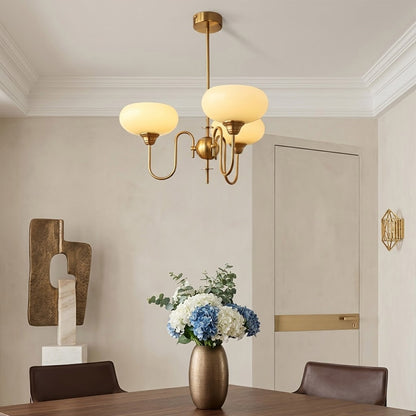 Solari cream glass chandelier above dining table warm amber gold light organic modern interior