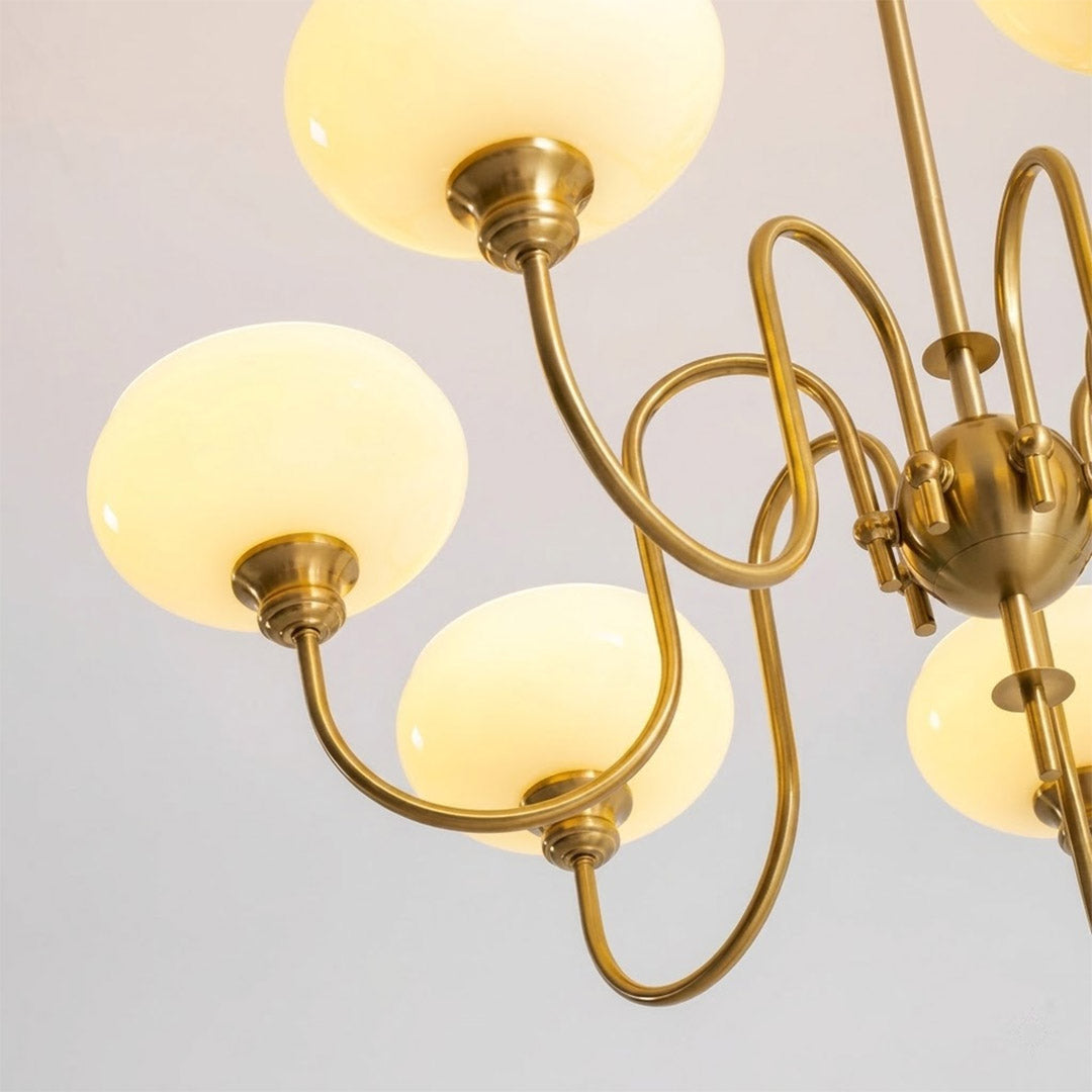 Solari cream glass chandelier above dining table warm amber gold light organic modern interior