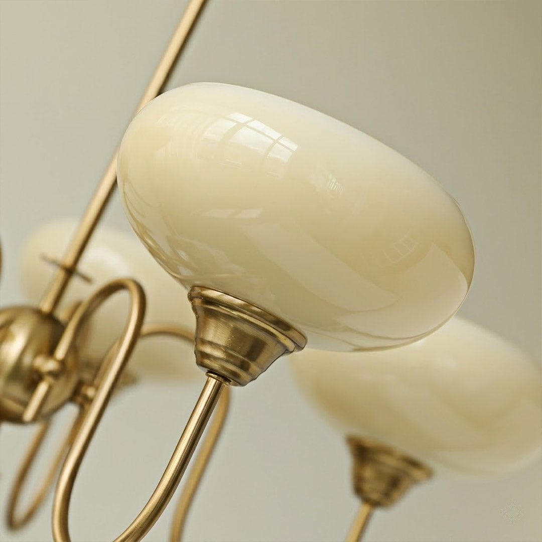 Solari cream glass chandelier above dining table warm amber gold light organic modern interior