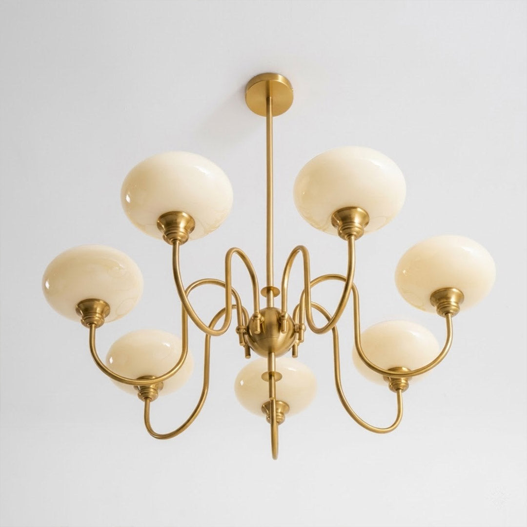 Solari cream glass chandelier above dining table warm amber gold light organic modern interior