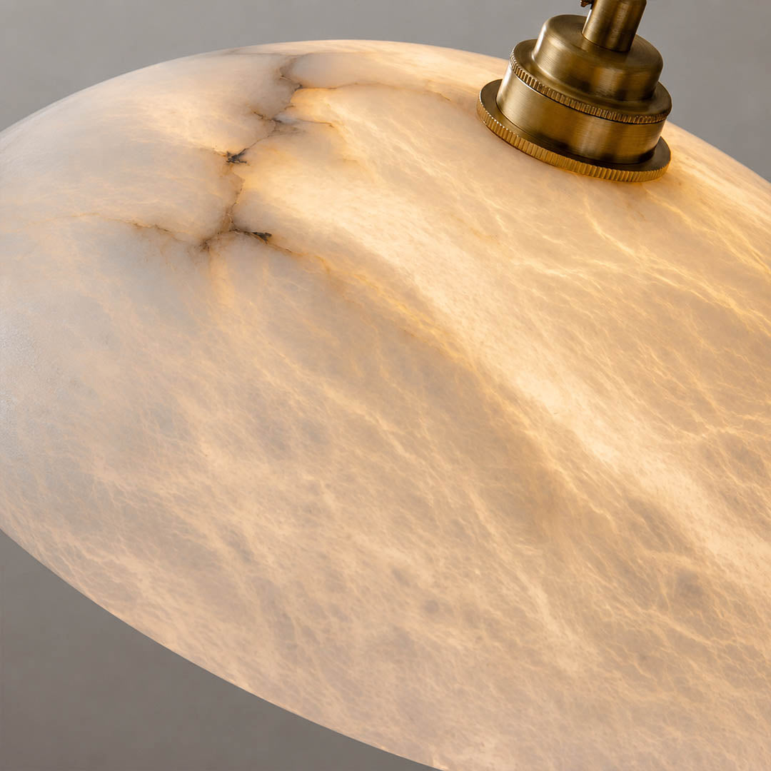 Sole alabaster pendant light illuminated glowing veining warm soft radiance translucent stone detail close up quiet luxury