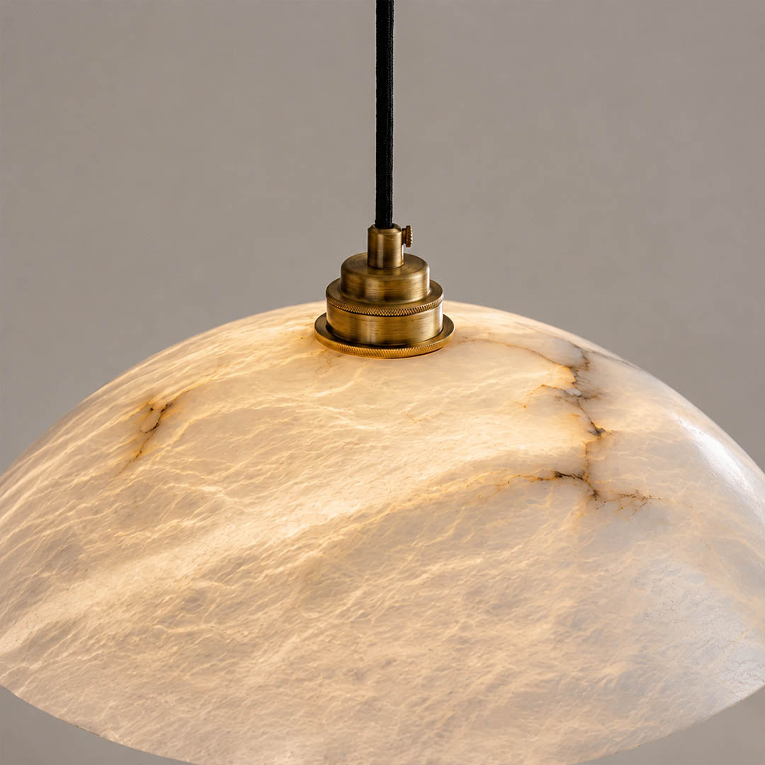 Sole alabaster pendant light illuminated glowing veining warm soft radiance translucent stone detail close up quiet luxury